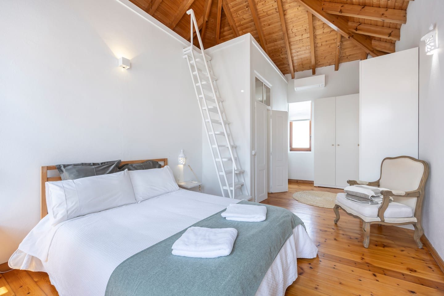Quarto da Casa Miclá com cama de casal e tecto de madeira